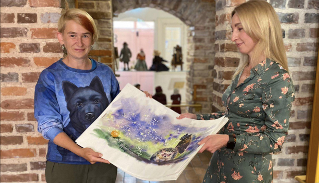 Lisatud pildil on kunstnik Anna Ryazanova kirjanik Marge Pärnitsale eelmise Mustika raamatu illustratsioone üle andmas.